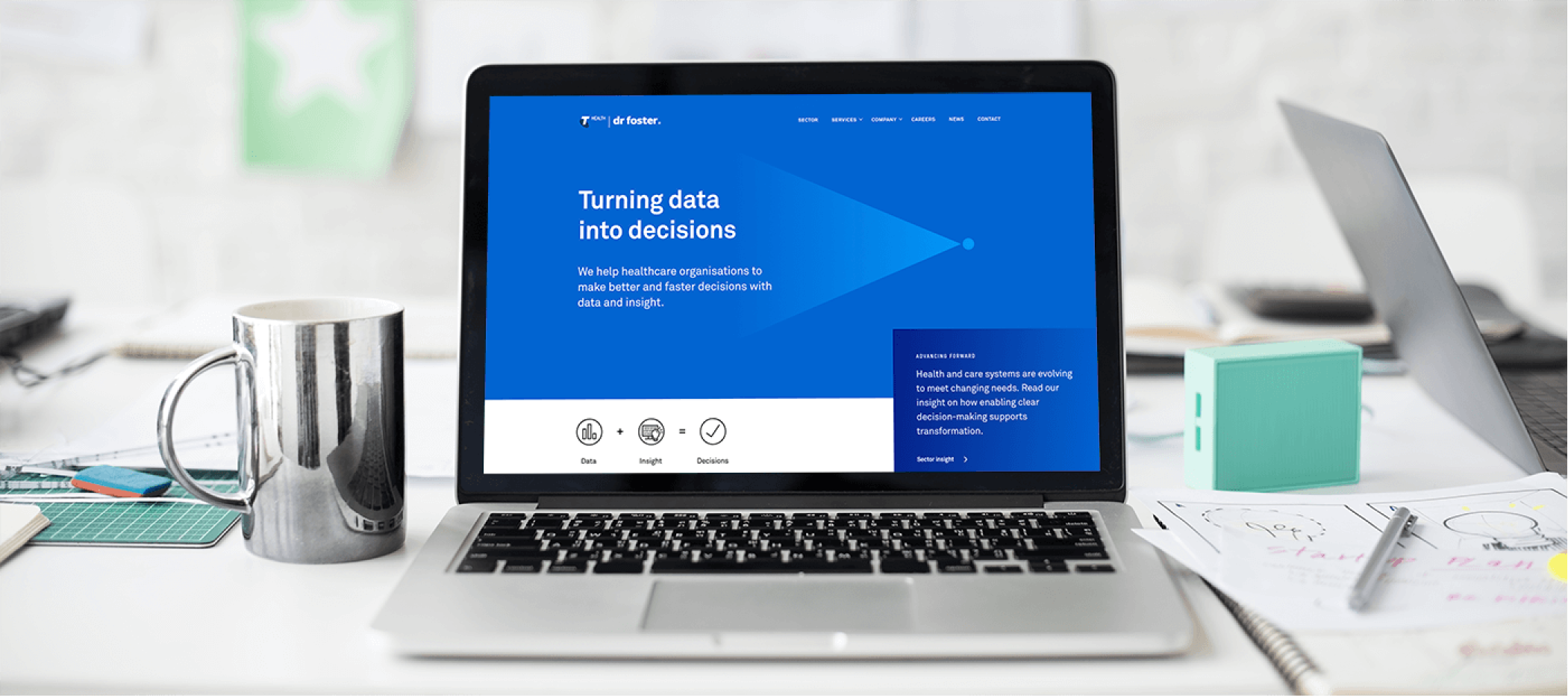 a stockphoto of a macbook on a desk with the welcome screen of the drfoster website inside.