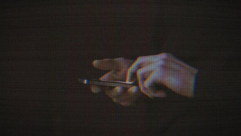 hands holding a phone in a dark space